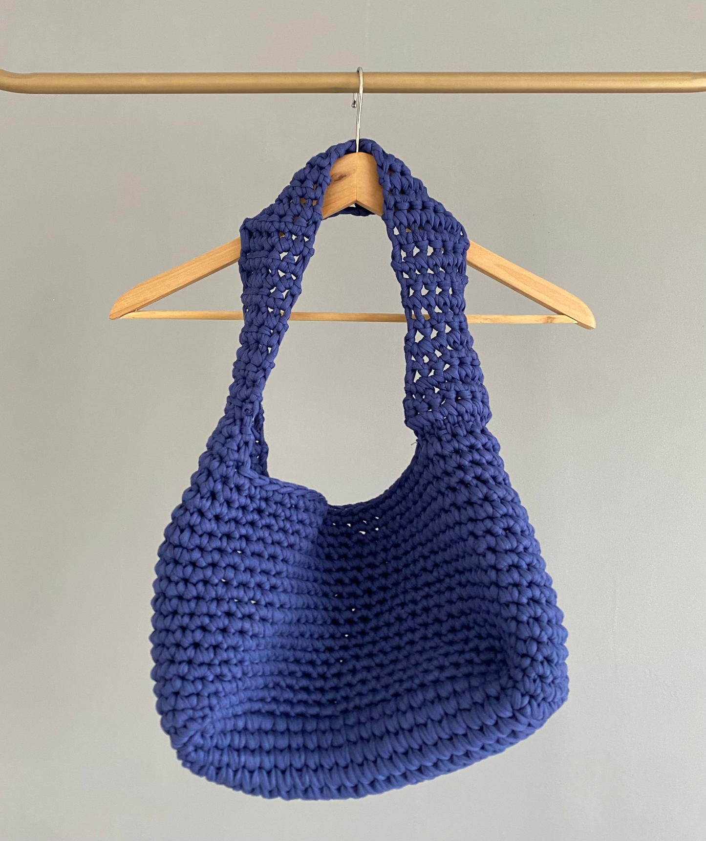 Sac en crochet en bandoulière bleu sur un cintre