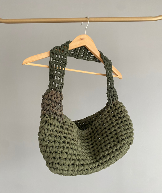 Sac en crochet vert kaki sur un cintre